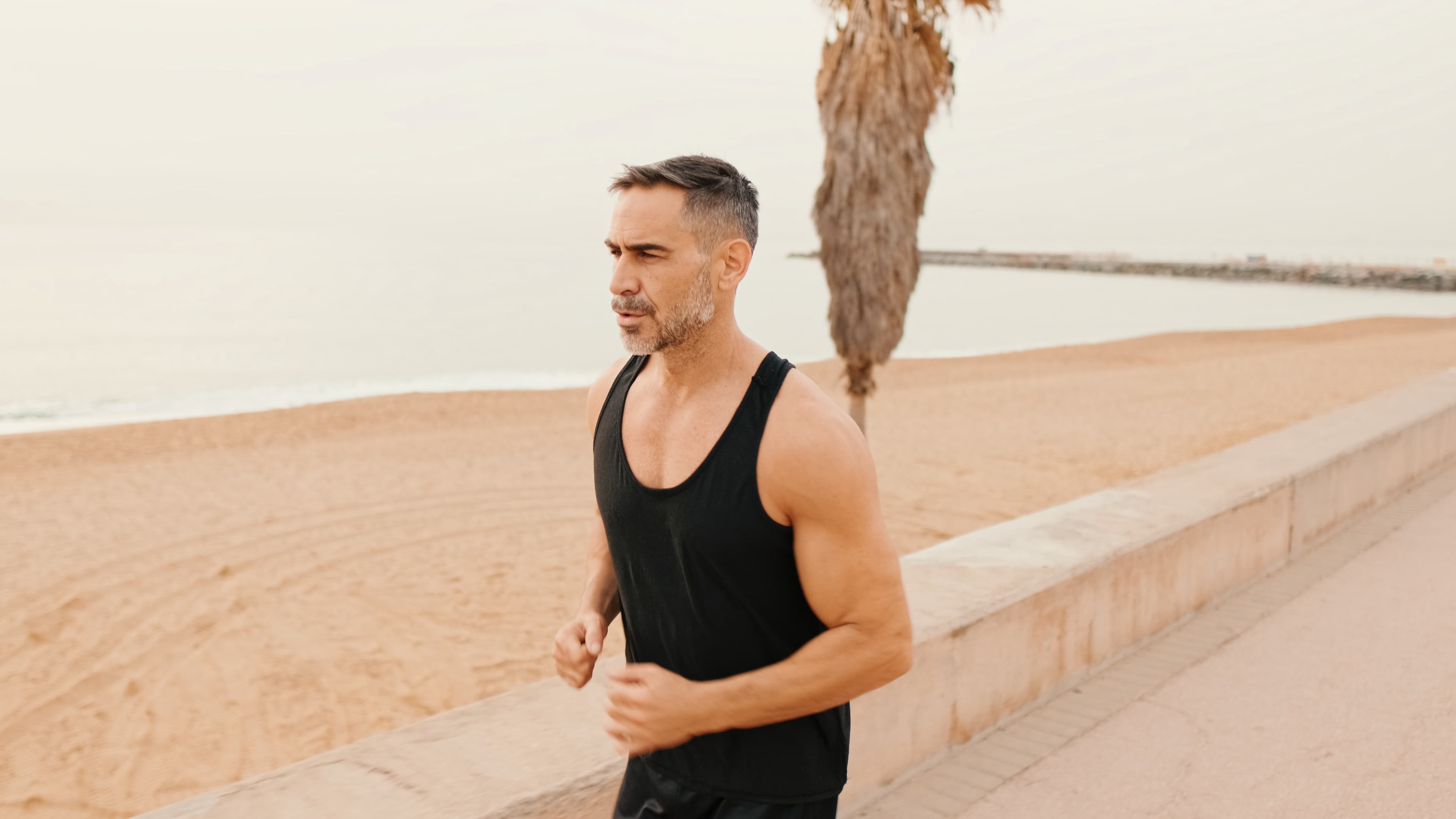 Middle-aged man running along a seaside promenade